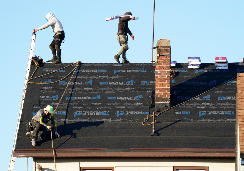 Workers replace the roof of an apartment building in Hawthorne, NJ, contributing to a surge in US housing supply