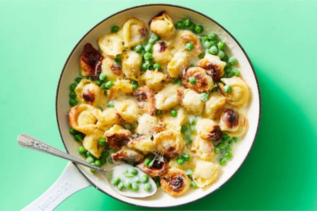 A dish of pasta and peas in a cream sauce.