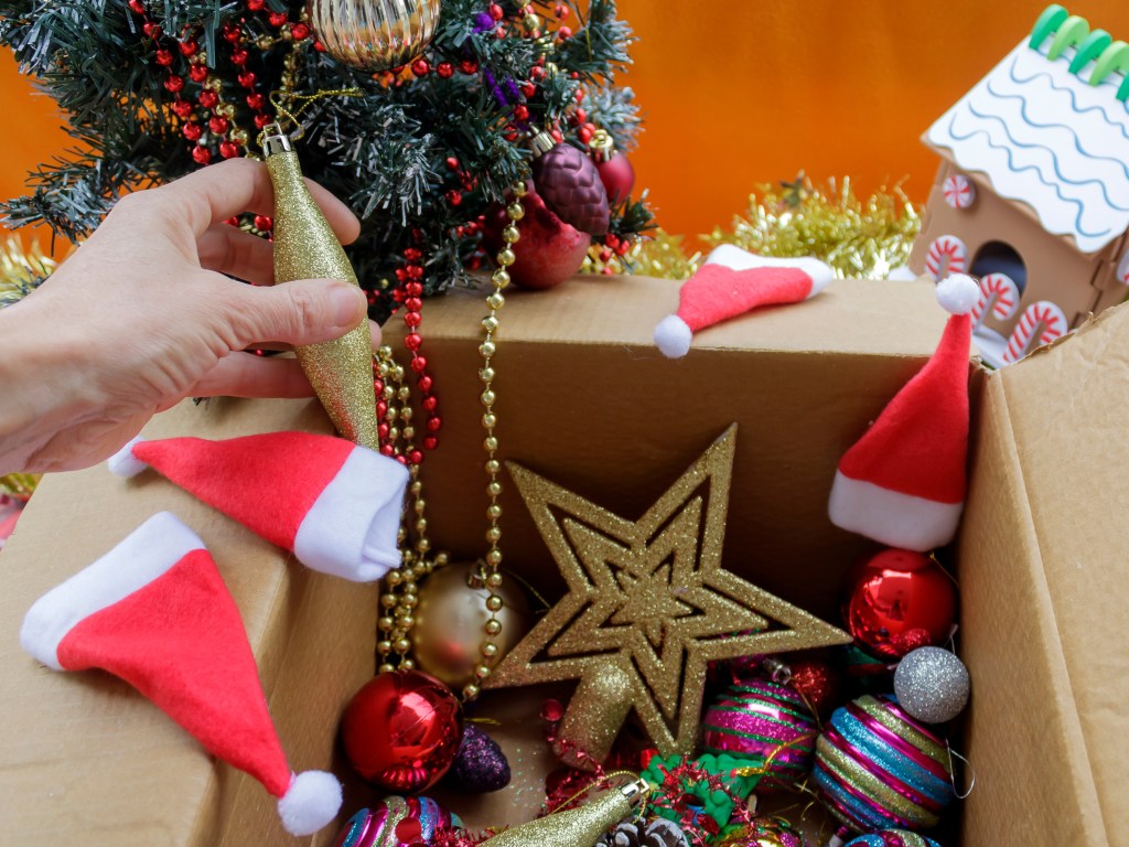 A gold glitter star, beads, Santa hats and a mini Christmas tree that he hand pulls out of a cardboard box.