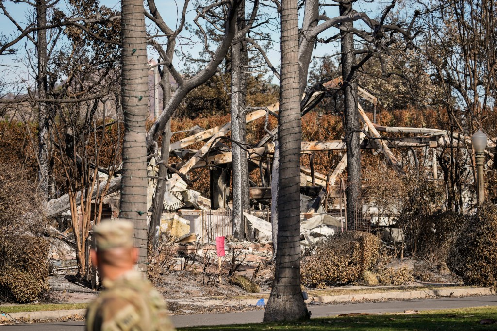 A member of the National Guard stands at a checkpoint as President Donald Trump tours damage from the Palisades Fire area in the Pacific Palisades neighborhood of Los Angeles, Friday, Jan. 24, 2025.