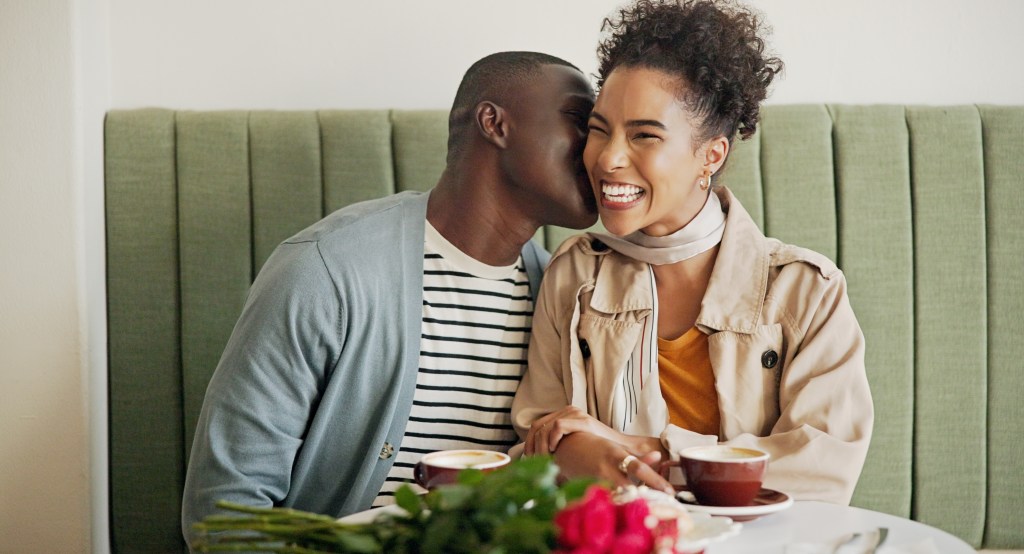 A man kissing a woman on the cheek in a cafe on Valentine's Day