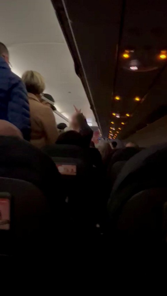 Security officers escorting a disruptive woman off a plane