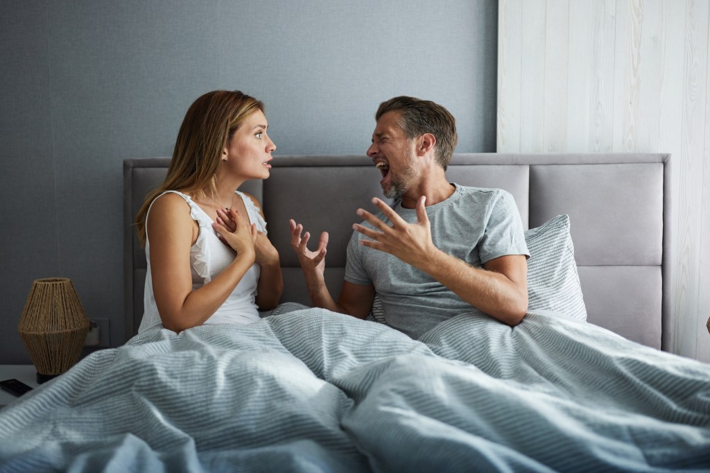 A disgruntled couple arguing about the issues of bedding during the morning