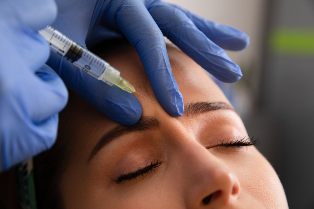 The young woman taking a botox injection to reduce the appearance of pores, finally lines and wrinkles