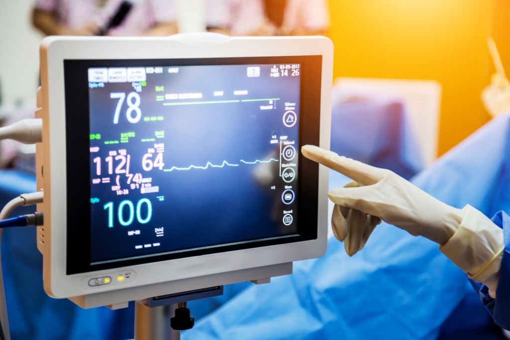 The doctor who shows in monitoring medical equipment indicating heartbeat