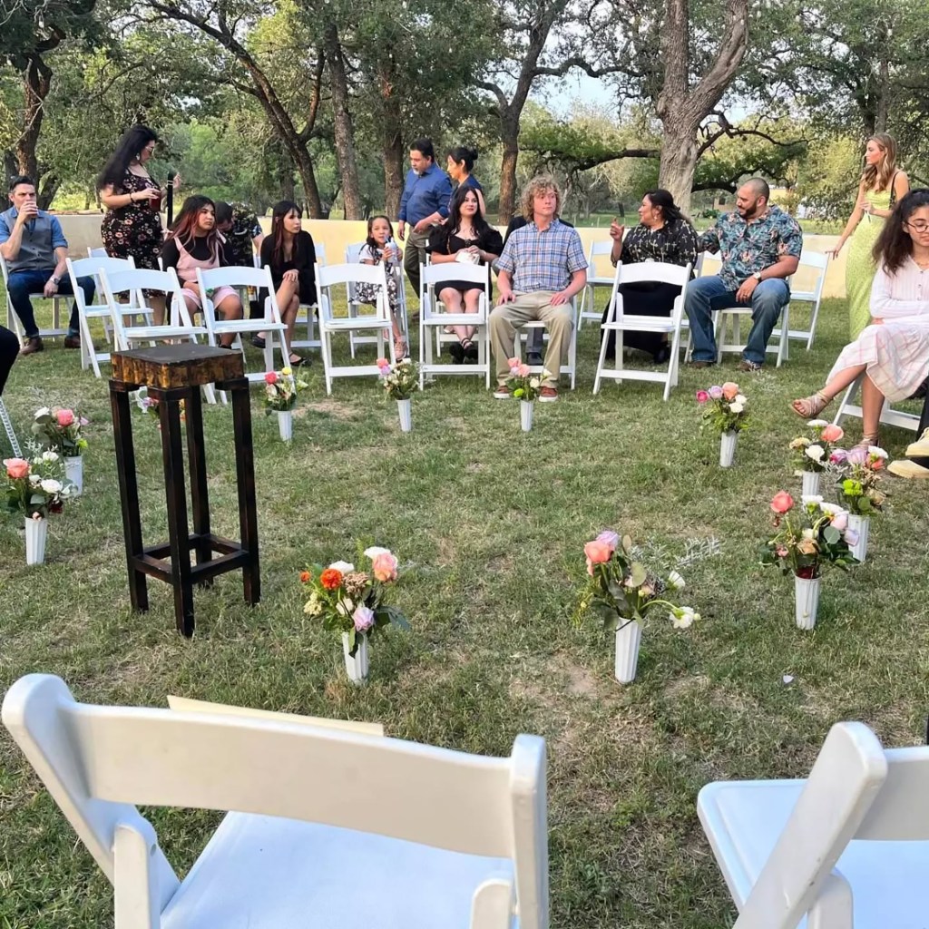 Trios wedding with white chairs in a circle around the alter