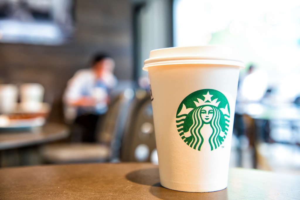 A long cup of Starbucks on a table at a Starbucks cafe in Berlin, Germany