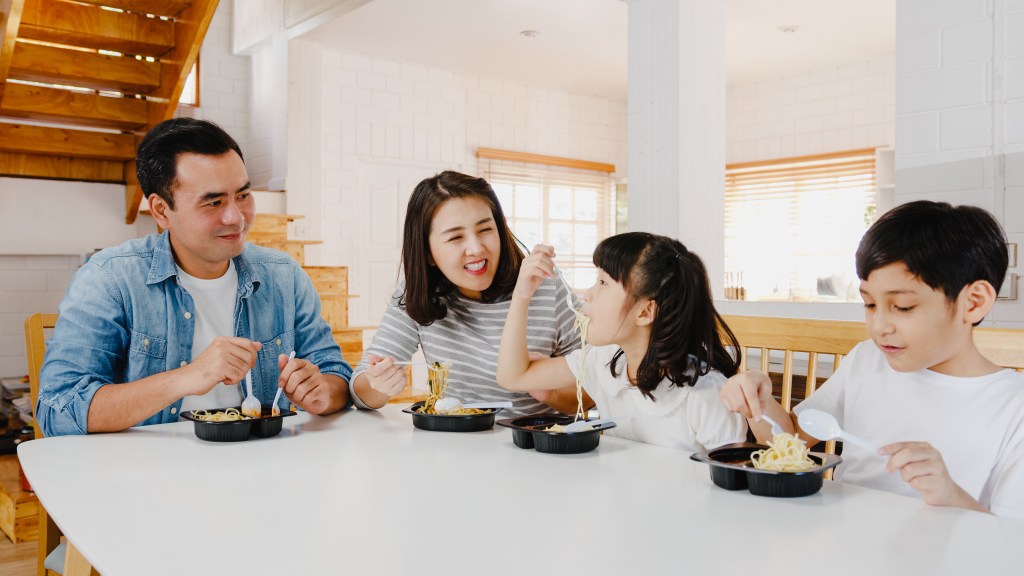 Asian family happily by eating pickup together at home 