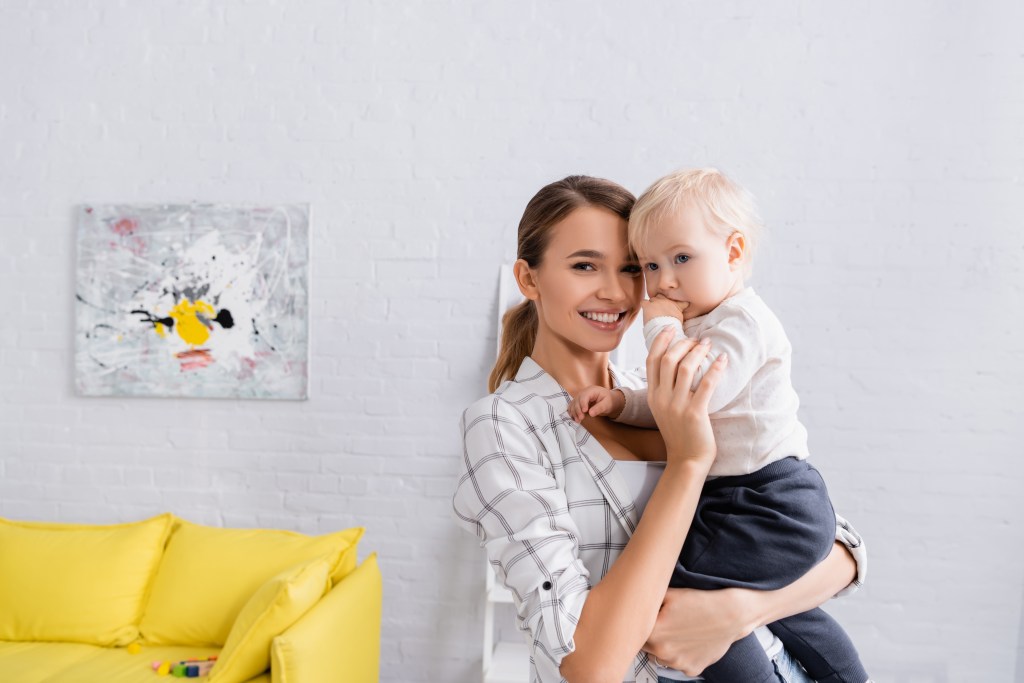 Happy mom with cute kids smiling at camera