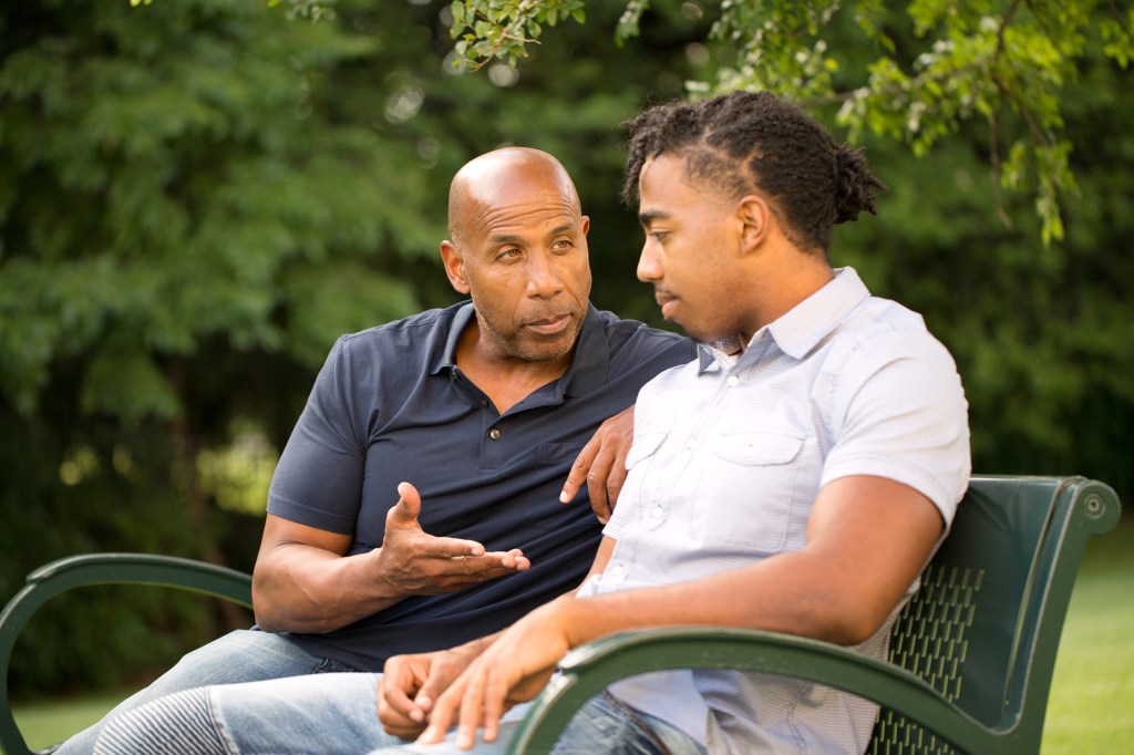 Father giving advice to the boy in the park 