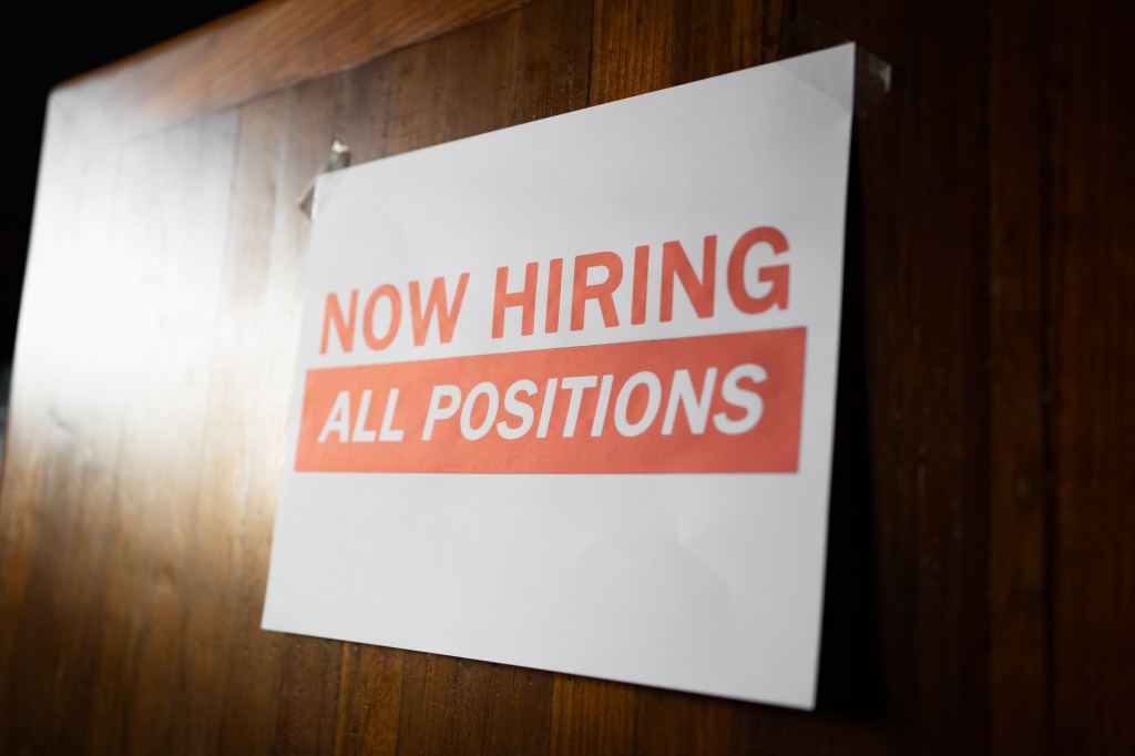 Now taking the employment sign posted on a wooden wall