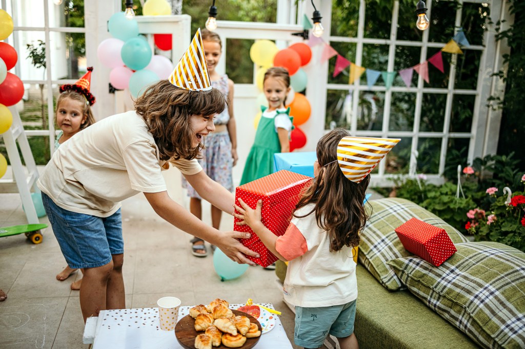 A group of children dressed in holiday hats at a family -back family party with gifts for his birthday boy and his three -year -old brother Spiderman