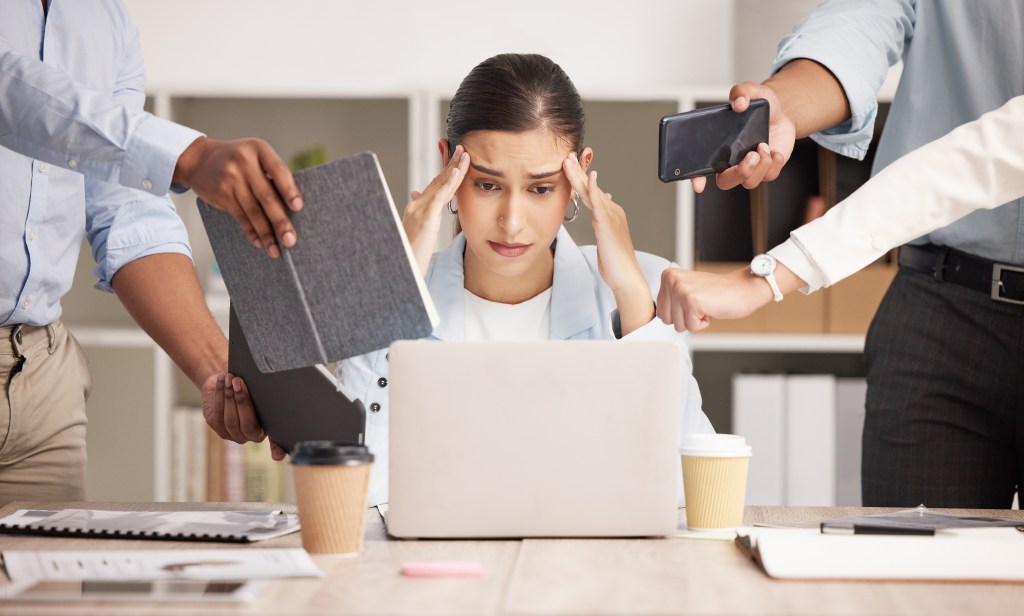 Stress, anxiety and multitasking business woman with headache from work load and laptop deadline in the office