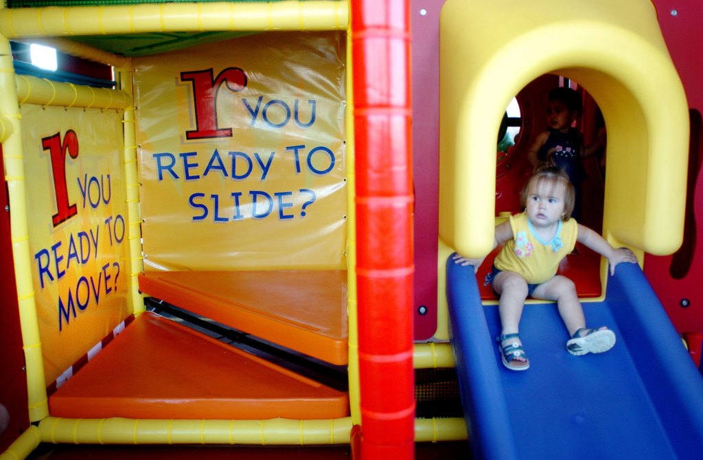 A child that descends a blue slide