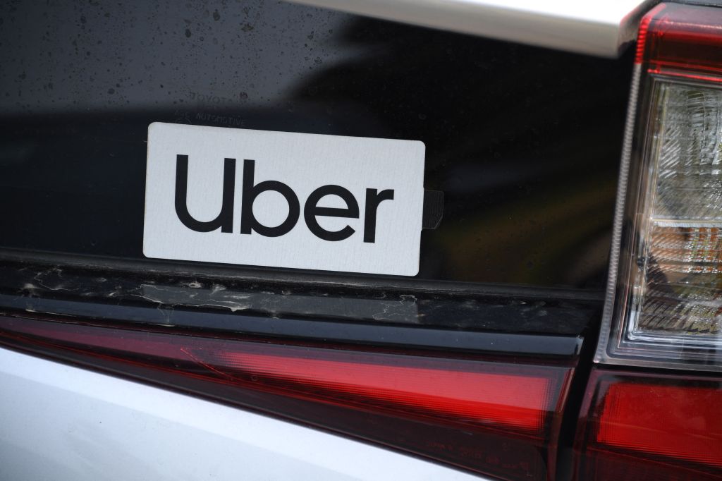 A picture of a Uber sticker is seen in a car.