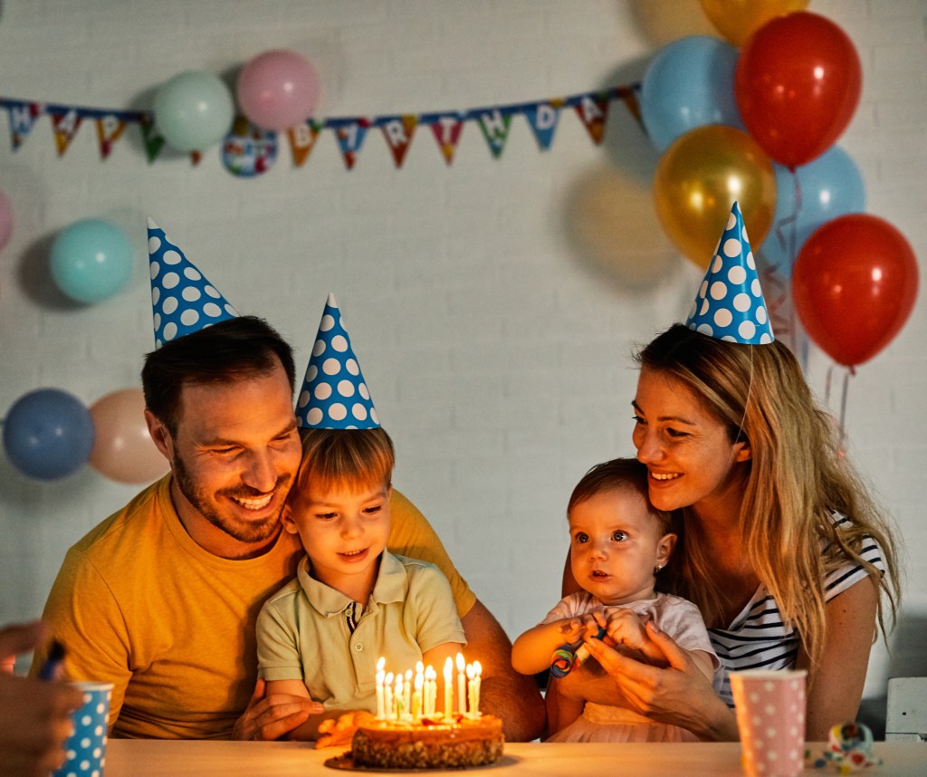 Happy family celebrating a birthday together at the table at home